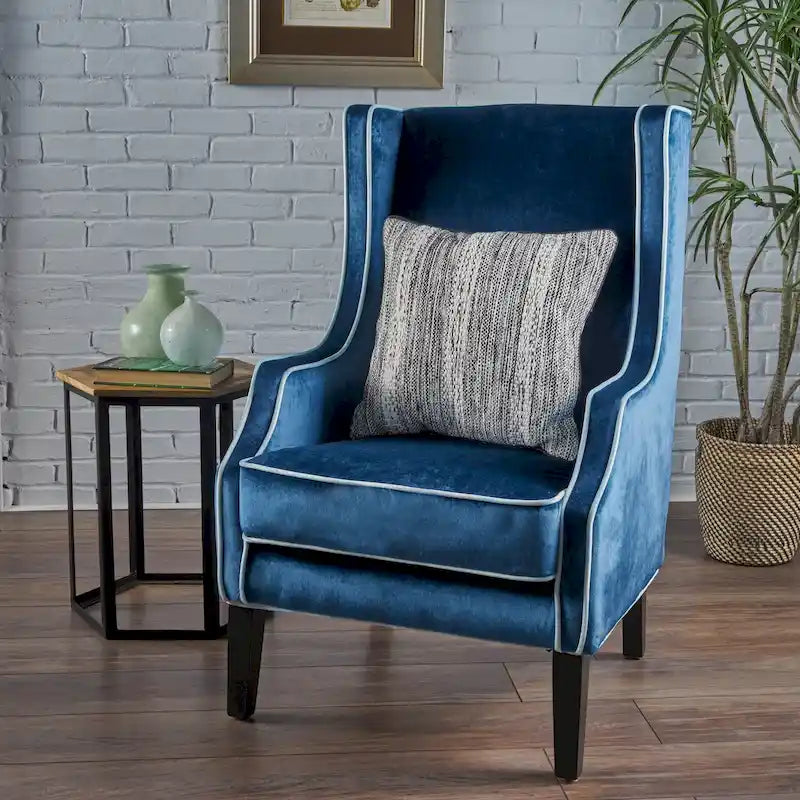 Poltrona decorativa con schienale alto e ali, rivestita in velluto, bordino bianco e gambe in legno nero