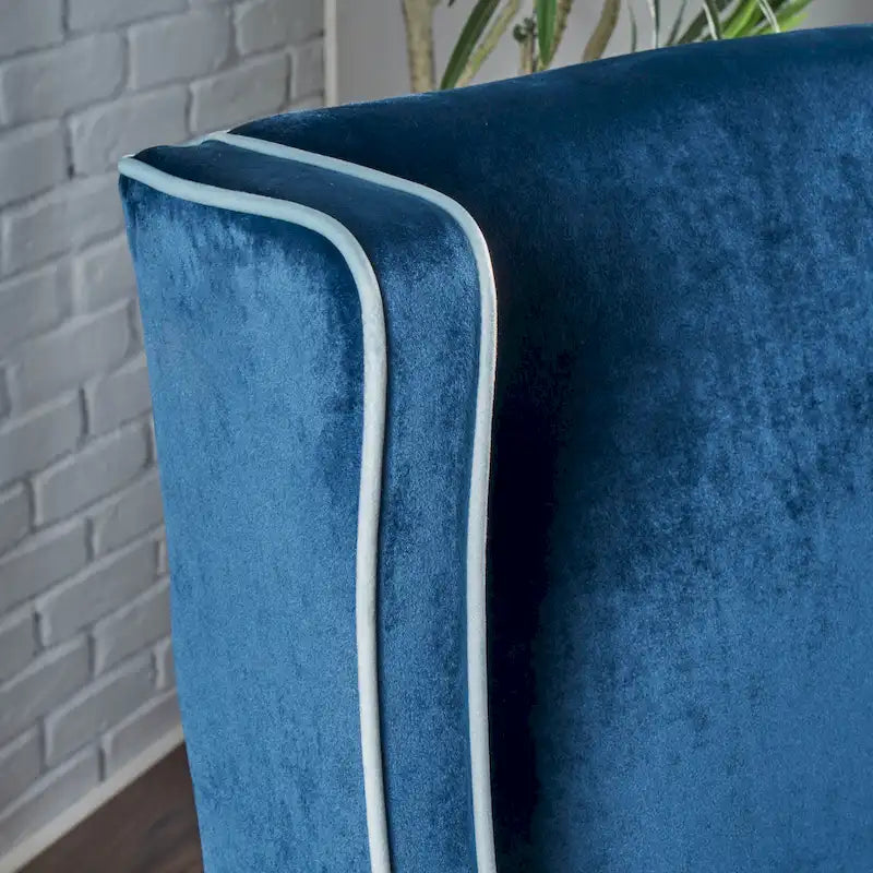 Poltrona decorativa con schienale alto e ali, rivestita in velluto, bordino bianco e gambe in legno nero