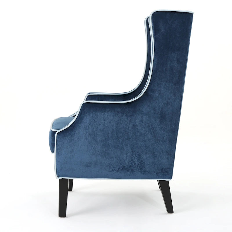 Poltrona decorativa con schienale alto e ali, rivestita in velluto, bordino bianco e gambe in legno nero