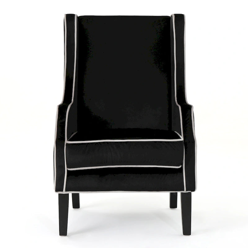 Poltrona decorativa con schienale alto e ali, rivestita in velluto, bordino bianco e gambe in legno nero
