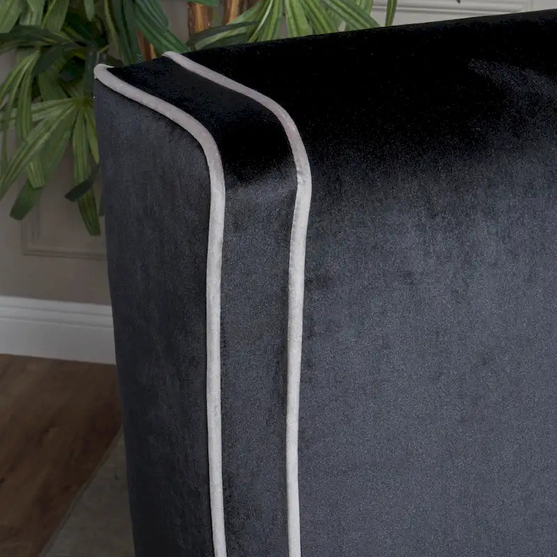 Poltrona decorativa con schienale alto e ali, rivestita in velluto, bordino bianco e gambe in legno nero