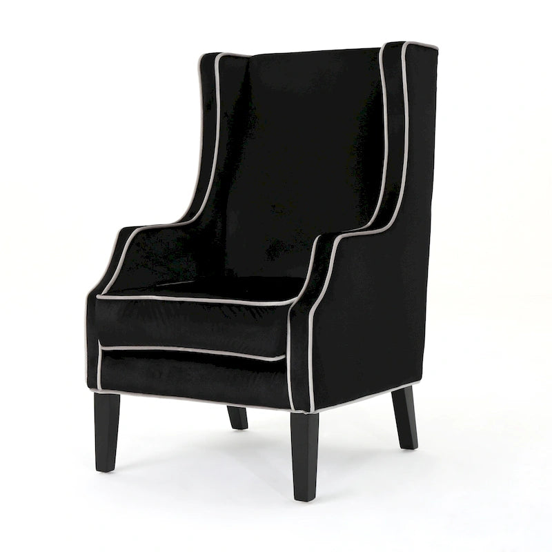 Poltrona decorativa con schienale alto e ali, rivestita in velluto, bordino bianco e gambe in legno nero