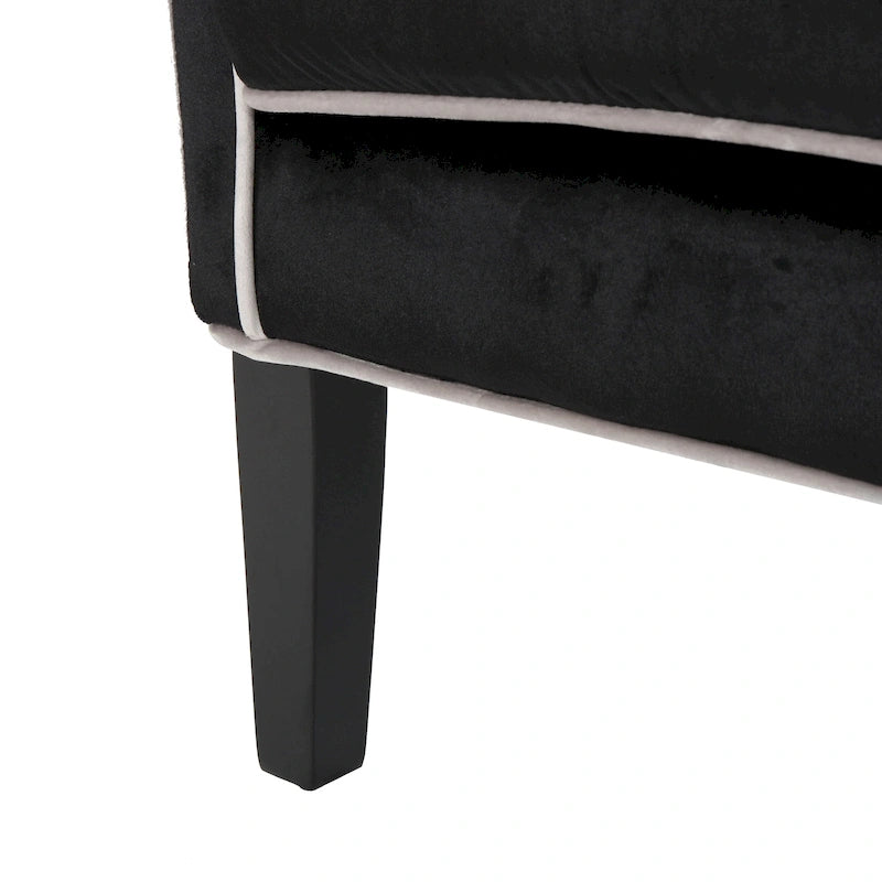 Poltrona decorativa con schienale alto e ali, rivestita in velluto, bordino bianco e gambe in legno nero