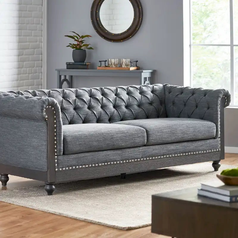 Divano Chesterfield con bordino a borchie, trapuntatura a bottoni e gambe in legno di betulla