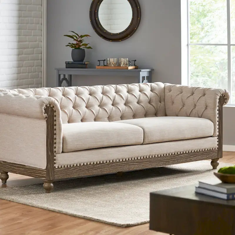 Divano Chesterfield con bordino a borchie, trapuntatura a bottoni e gambe in legno di betulla