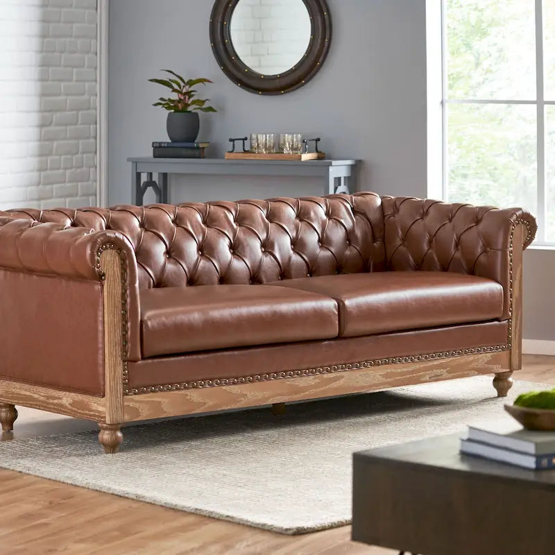 Divano Chesterfield con bordino a borchie, trapuntatura a bottoni e gambe in legno di betulla
