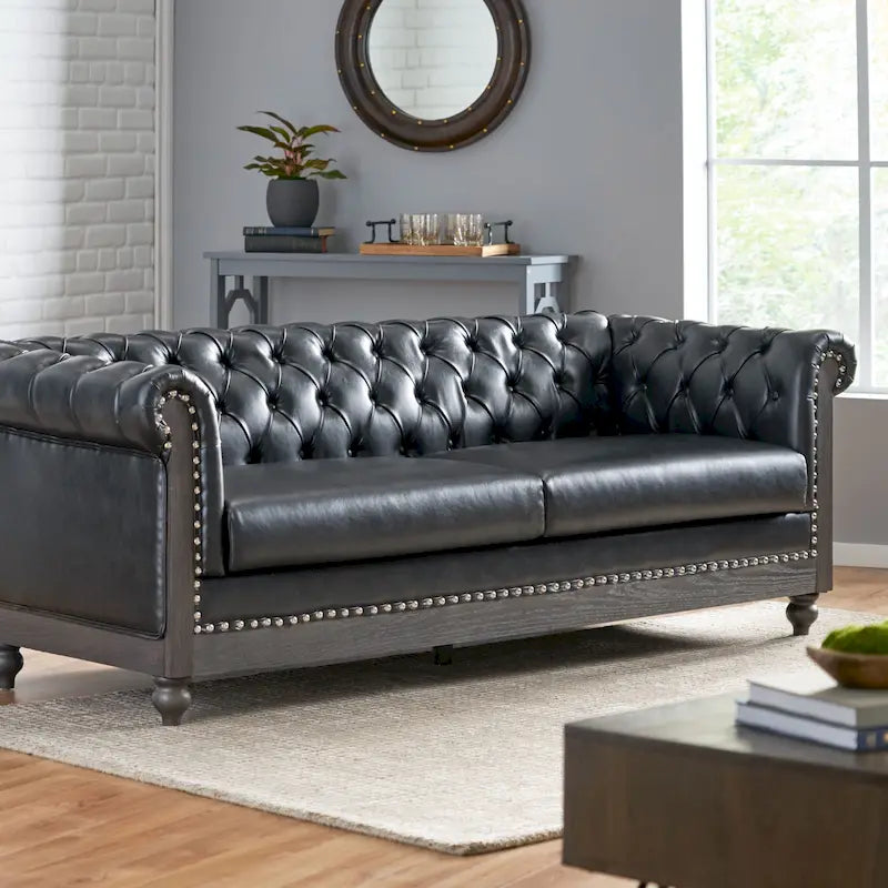 Divano Chesterfield con bordino a borchie, trapuntatura a bottoni e gambe in legno di betulla