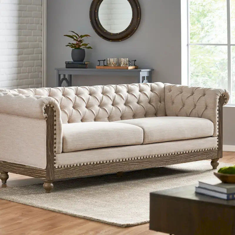 Divano Chesterfield con bordino a borchie, trapuntatura a bottoni e gambe in legno di betulla