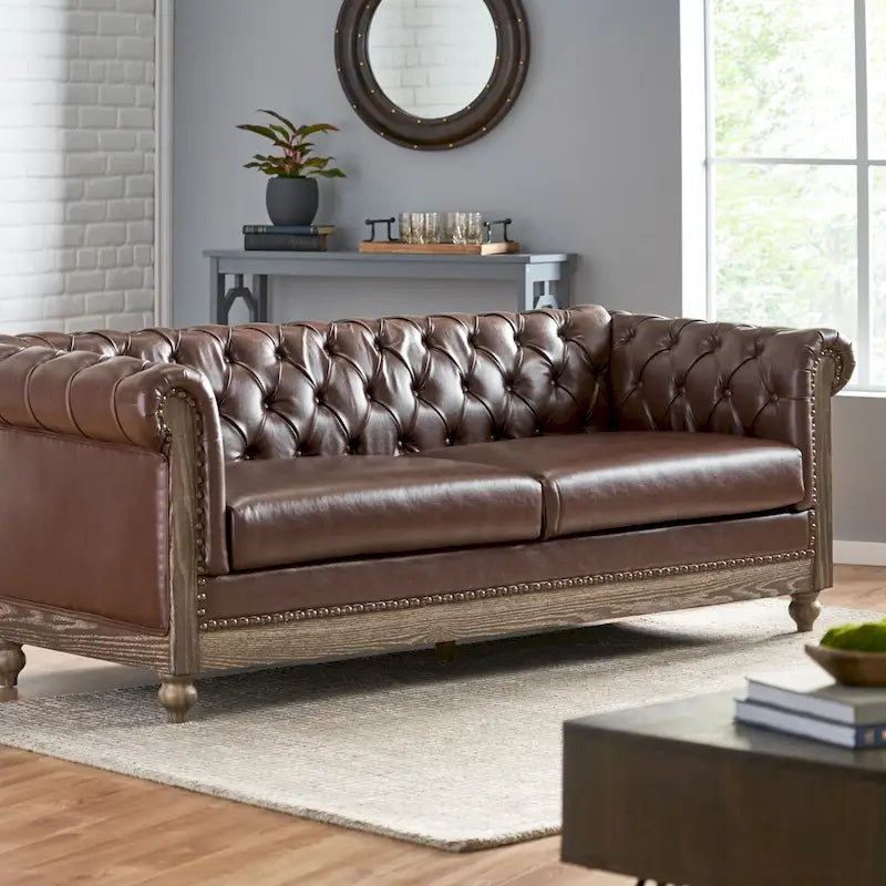 Divano Chesterfield con bordino a borchie, trapuntatura a bottoni e gambe in legno di betulla